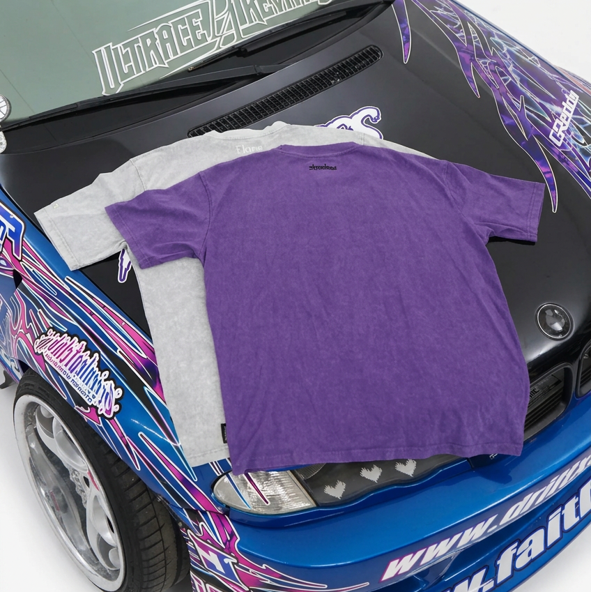 Shadow and Flare tees, back view, laid on the hood of a blue Faithless drift car
