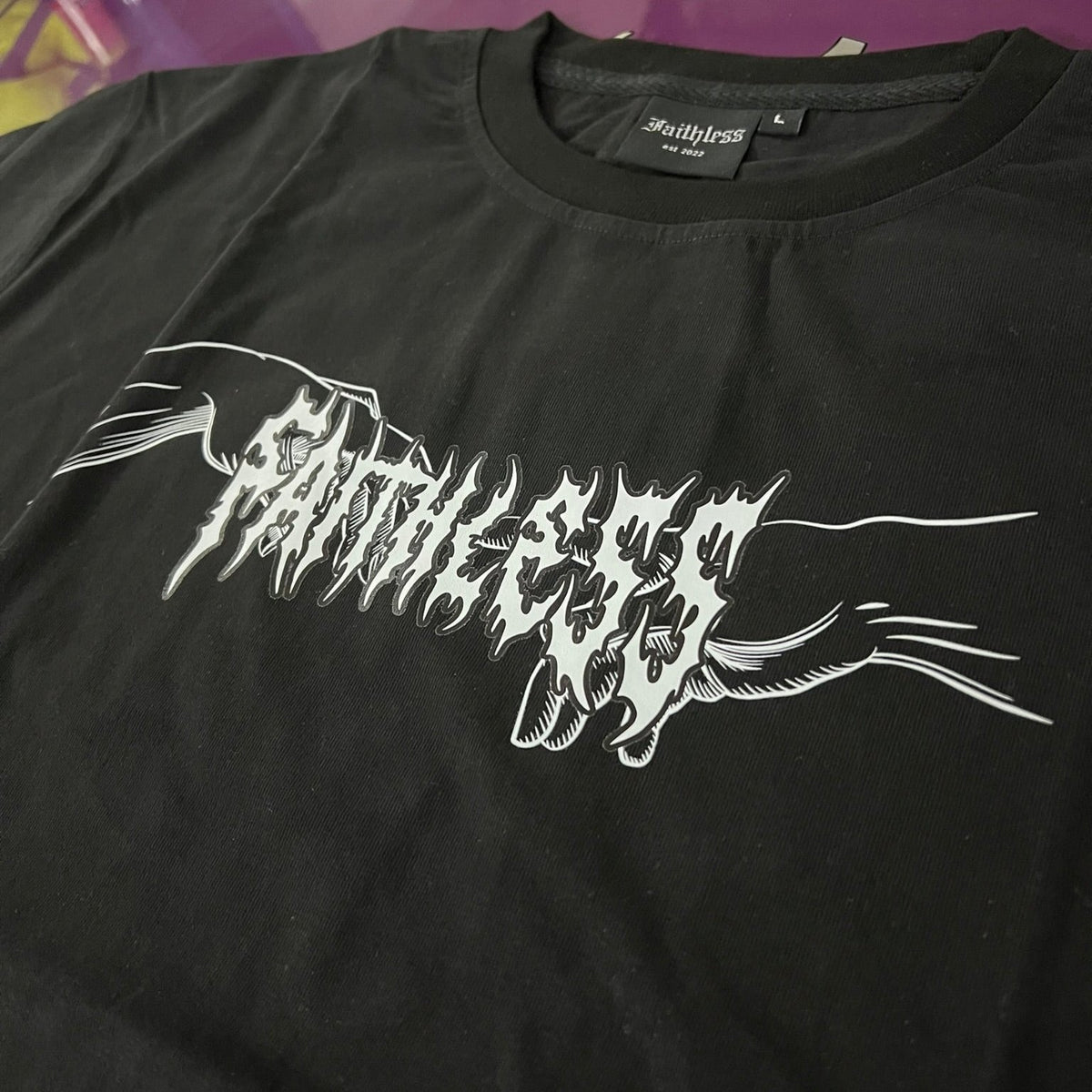 Close-up of the white Faithless chest print with a reaching hand on the Angel tee