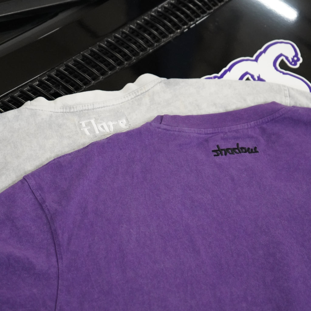 Back necks of the Flare and Shadow tees with their name embroideries